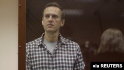 Kremlin critic Alexei Navalny stands inside a defendant dock during a court hearing in Moscow, Russia, Feb. 20, 2021, in this still image taken from video. (Press Service of Babushkinsky District Court of Moscow/Handout)