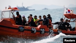 South Korean divers operate at the site where the capsized passenger ship Sewol sank off Jindo, South Korea, on April 20, 2014.