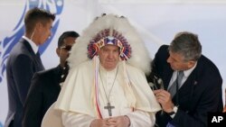FILE - Pope Francis dons a headdress that was gifted to him during a visit with Indigenous peoples at Maskwaci, the former Ermineskin Residential School, in Maskwacis, Alberta, July 25, 2022.