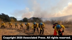A hotshot crew works on a fireline while the Bond Fire burns in Silverado, Calif., on Dec. 3, 2020. 
