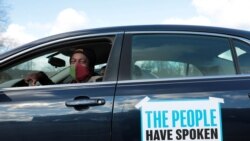 Tristan Taylor demonstrates in a car caravan as the Board of State Canvassers meet to certify the results of the election in Lansing, Michigan, Nov. 23, 2020.