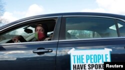 Tristan Taylor demonstrates in a car caravan as the Board of State Canvassers meet to certify the results of the election in Lansing, Michigan, Nov. 23, 2020.