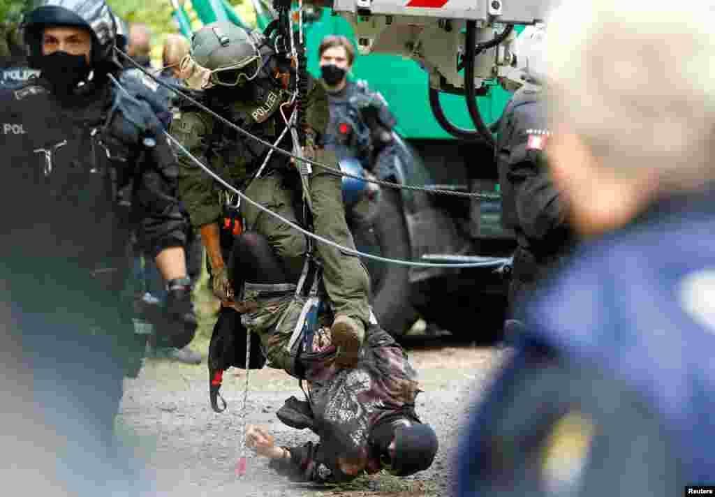 A special forces police officer brings down a protester staging a blockade as the police and forest workers clear a camp at the Dannenrod forest during a protest by environmentalists against the extension of the highway Autobahn 49, in Dannenrod, Germany.