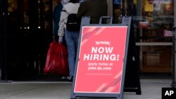 FILE - A hiring sign is displayed outside of a retail store in Vernon Hills, Illinois, Nov. 13, 2021.