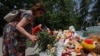 Seorang perempuan menaruh bunga di area memorial sementara di Sevastopol, Krimea, pada 24 Juni 2024. Memorial tersebut dibuat untuk mengenang korban dari serangan misil di Krimea, yang menurut otoritas Rusia dilakukan oleh Ukraina. (Foto: Reuters/Alexey Pavlishak) 