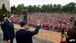 Chinese President Xi Jinping, center, accompanied by Serbian President Aleksandar Vucic, greets the people gathered outside the Palace of Serbia during a a welcome ceremony in Belgrade on May 8, 2024. (Serbia's Presidential Press Service via AFP)