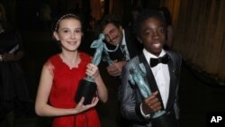 Millie Bobby Brown, left, and Caleb McLaughlin appear backstage with the awards for outstanding performance by an ensemble in a drama series for “Stranger Things” at the 23rd annual Screen Actors Guild Awards at the Shrine Auditorium & Expo Hall, Jan. 29,