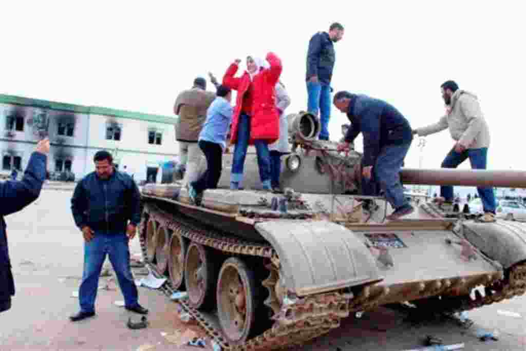 Manifestantes subidos encima de un tanque de als fuerzas armadas.