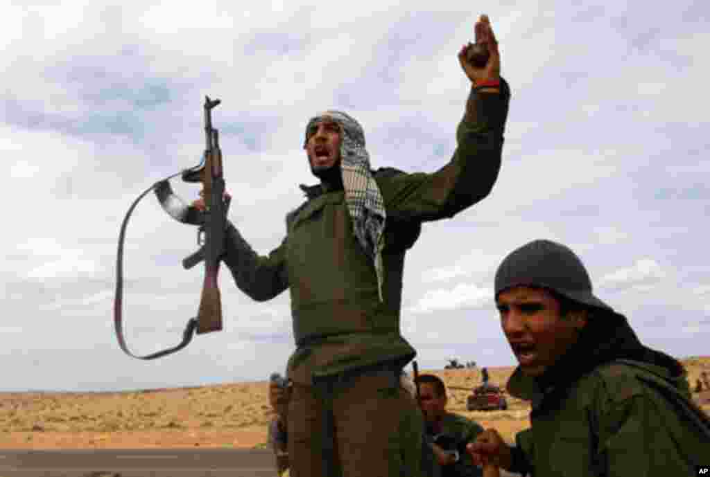 Rebel fighter shouts "Allahu Akbar" during battle with forces loyal to Libyan leader Moammar Gadhafii on a road between Ras Lanuf and Bin Jawad, March 28, 2011