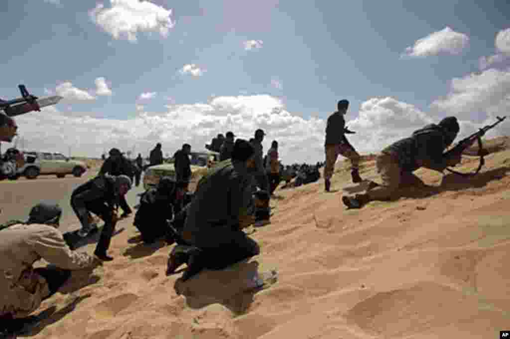 Libyan rebels duck for cover during a failed attempt to take the town of Ajdabiya from Moammar Gadhafi's forces, March 21, 2011