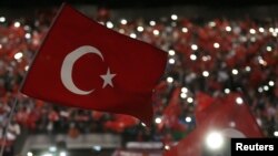 FILE - Supporters of Turkey's President Tayyip Erdogan wave Turkey's national flags as they wait for his speech during a rally against terrorism in Strasbourg, France, Oct. 4, 2015.