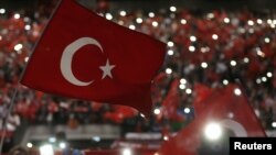 Supporters of Turkey's President Tayyip Erdogan wave Turkey's national flags as they wait for his speech during a rally against terrorism in Strasbourg, France, Oct. 4, 2015.