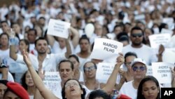 Friends and relatives hold signs with the names of victims, during a march paying homage to the victims of a mining dam collapse a week ago, in Brumadinho, Brazil, Friday, Feb. 1, 2019. 