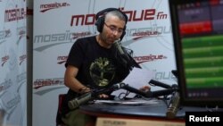 FILE— Tunisian journalist Haythem El Mekki presents his segment in an episode of a radio show inside the studio of Mosaique FM, in Tunis, Tunisia, October 4, 2022.