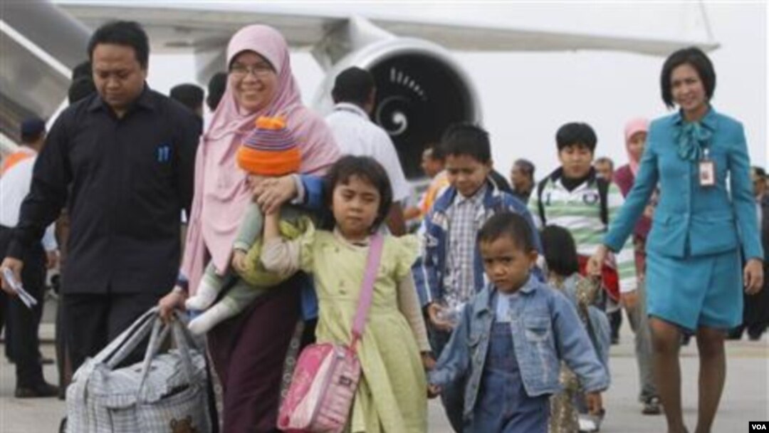Sebagian dari kloter pertama WNI dari Mesir, berjalan di landasan pacu sesaat setelah turun dari pesawat mereka di Bandara Internasional Soekarno-Hatta, Jakarta, Rabu