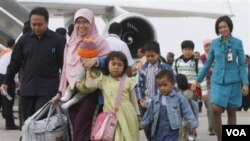 Sebagian dari kloter pertama WNI dari Mesir, berjalan di landasan pacu sesaat setelah turun dari pesawat mereka di Bandara Internasional Soekarno-Hatta, Jakarta, Rabu