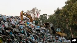 A bulldozer moves piles of garbage in Karantina, east Beirut, Lebanon, Nov. 1, 2015.