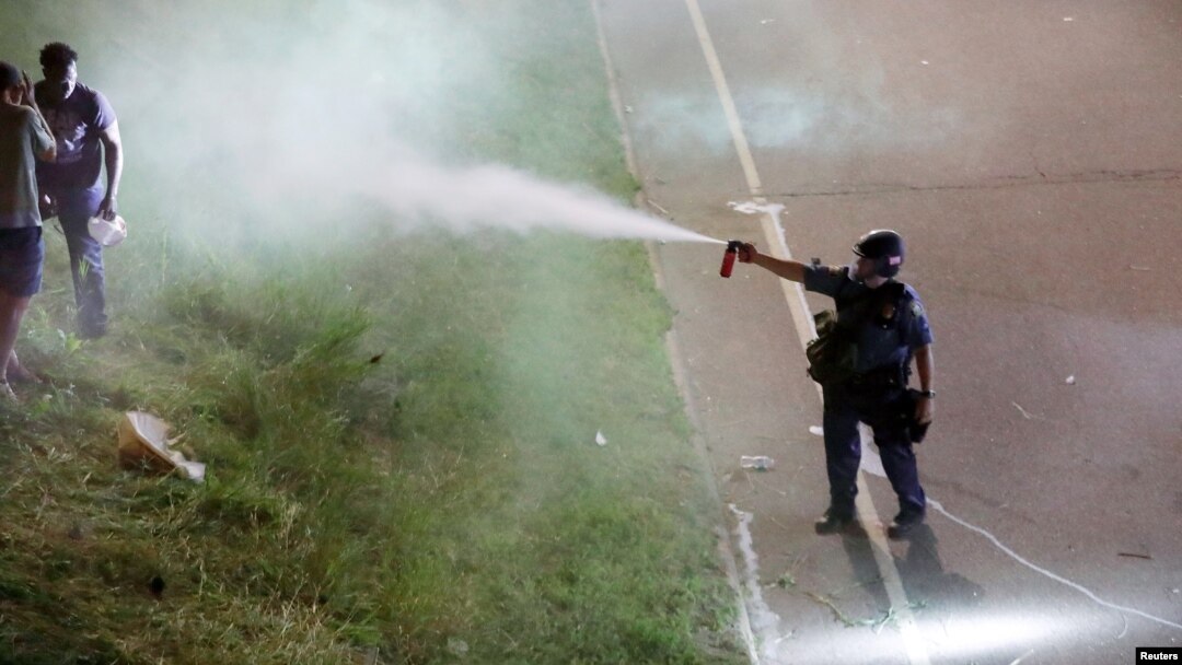 A police officer uses pepper spray as people gather on Interstate 94 to protest the fatal shooting of Philando Castile by Minneapolis area police during a traffic stop, in St. Paul, Minnesota, July 9, 2016. (Reuters) 