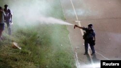 A police officer uses pepper spray as people gather on Interstate 94 to protest the fatal shooting of Philando Castile by Minneapolis area police during a traffic stop, in St. Paul, Minnesota, July 9, 2016. (Reuters) 