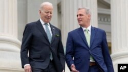 ARCHIVO: El presidente de EEUU, Joe Biden, conversa con el presidente de la Cámara de Representantes, Kevin McCarthy durante un evento en el Capitolio el 17 de marzo de 2023.