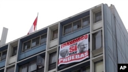 A banner that shows images of Pope Francis and Luis Figari, the founder of a Catholic lay movement in Peru, that reads, "Francisco, here we do have proof," hangs in Lima on Jan. 21, 2018. Francis on Sept. 25, 2024, expelled 10 people in connection with abuses within the group.