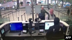 Michael Taylor (nomor dua dari kanan) dan George Antoine Zayek (tengah), dua pria yang dituduh membantu pengusaha buronan Carlos Ghosn melarikan diri, di pemeriksaan paspor di Bandara Istanbul, Turki, 17 Januari 2020. (Foto: HO/Kepolisian Turki/AFP) 