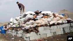 FILE - An Afghan man prepares to set narcotics on fire on the outskirts of Kabul, Oct. 29, 2014.