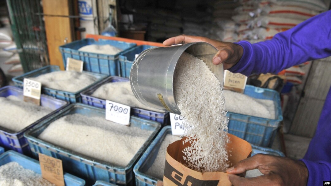 Seorang pedagang beras eceran di Jakarta, tengah memasukkan beras ke dalam kantong kertas di tokonya, 4 Februari 2011. (AFP PHOTO / ROMEO). 