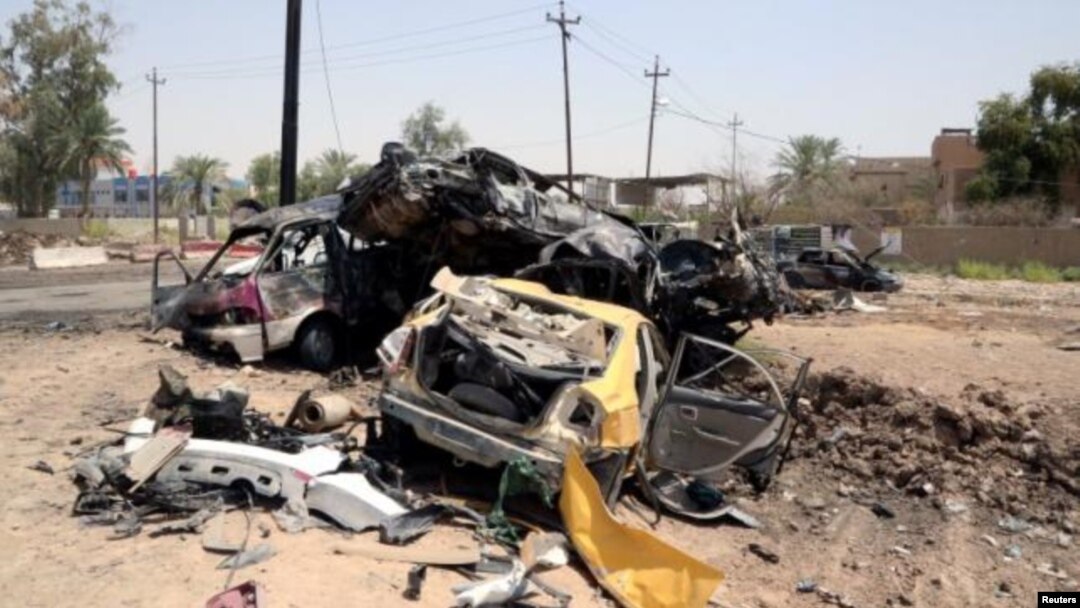 Beberapa kendaraan hancur terlihat di TKP bom bunuh diri di Khalis, sebelah utara Baghdad, Irak Senin (25/7).