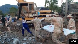 The rescue team carry a dead body on Sunday morning in Kep province as the death toll has risen to 28. (Sun Narin/VOA Khmer)