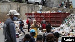 ARCHIVO - La gente se reúne cerca de un vertedero de desechos en el barrio de Petare, Caracas el 4 de agosto de 2020, en medio de la pandemia de COVID-19.
