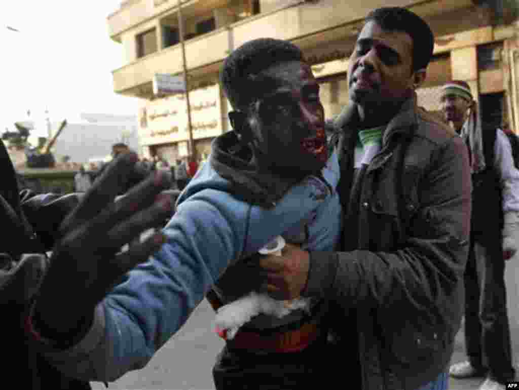 A medic attempts to treat an injured anti-government protester during clashes in Tahrir, or Liberation square, in Cairo, Egypt, Wednesday, Feb. 2, 2011. Several thousand supporters of President Hosni Mubarak clashed with anti-government protesters as Egyp
