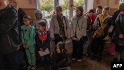 Children gather in a school during their evacuation to western Ukraine, from the southern city of Kherson, on Oct. 30, 2023, amid the Russian invasion of Ukraine.