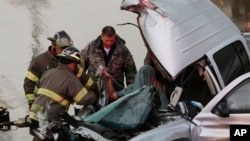 First responders work to free a passenger from a truck involved in an accident on Interstate Highway 35 during severe weather in Moore, Okla., May 6, 2015. 