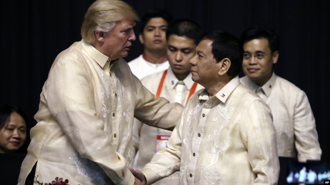 Presiden AS Donald Trump (kiri) berjabat tangan dengan Presiden Filipina Rodrigo Duterte pada acara jamuan makan malam KTT ASEAN di Manila, Minggu (12/11).