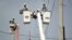 FILE - In this Oct. 19, 2017, photo, a brigade from the Electric Power Authority repairs distribution lines damaged by Hurricane Maria in the Cantera community of San Juan, Puerto Rico.