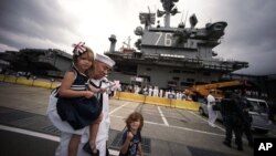 Tripulantes del portaaviones USS Ronald Reagan se reunieron con sus familiares a su llegada al puerto japonés de Yokosuka, al sur de Tokio, el jueves, 1 de octubre de 2015.
