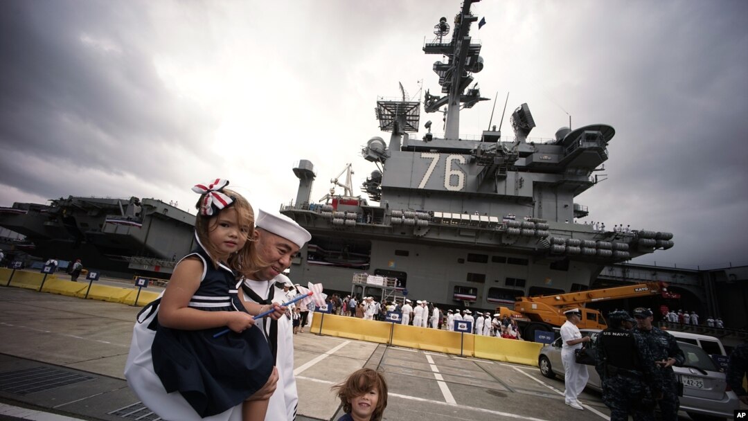 Crew members of U.S. navy nuclear-powered aircraft carrier USS Ronald Reagan reunite their loved ones upon arrival at the U.S. Navy's Yokosuka base in Yokosuka, south of Tokyo Thursday, Oct. 1, 2015.