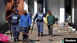 Police officers detain demonstrators during protests following the imprisonment of former South Africa President Jacob Zuma, in Katlehong, South Africa, July 12, 2021. 