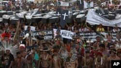 FILE - Indigenous protesters from various ethnic groups carry fake coffins representing indians killed over the demarcation of land, as they demand the demarcation of indigenous lands, outside the National Congress in Brasilia, Brazil, April 25, 2017.