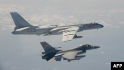 یک جت F-16 تایوان در کنار یک بم افگن H-6 چین در حریم هوایی تایوان پرواز می کند (تصویر از آرشیف صدای امریکا)‌