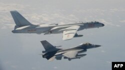 Pesawat jet tempur F-16 Taiwan terbang di sebelah pesawat pengebom H-6 China (atas) di wilayah udara Taiwan, 10 Februari 2020. (Foto: Kementerian Pertahanan Taiwan via AFP)