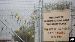 Flowers decorate a fence outside of Fort Hood's east gate, April 6, 2014, in Killeen, Texas, in honor of those killed and wounded in the Fort Hood shooting on April 2. 