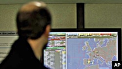 A man walks by a display screen which shows the Libyan 'No-Fly' zone, highlighted in blue at bottom right, at Eurocontrol in Brussels, March 18, 2011