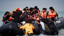 Sejumlah migran yang berupaya untuk mencapai Inggris dengan menyeberangi Selat Inggris, naik ke atas perahu karet yang berangkat dari wilayah Wimereux, Prancis, pada 4 September 2024. (Foto: Reuters/Benoit Tessier)