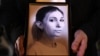 FILE - A colleague of Ukrainian journalist Victoria Roshchyna holds a photograph of her during an event to honor her at a makeshift memorial for fallen Ukrainian soldiers, at Independence Square in Kyiv, on Oct. 11, 2024.