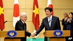 Vietnamese Communist Party General Secretary Nguyen Phu Trong, left, shakes hands with Japan's Prime Minister Shinzo Abe, right, following their joint press announcement at Abe's official residence in Tokyo, Sept. 15, 2015. 