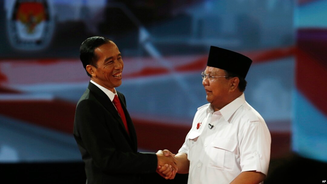 Calon presiden Indonesia Jokowi berjabat tangan dengan Prabowo Subianto sesudah acara debat presiden (15/6). Dalam masa kampanye presiden ini banyak terjadi kampanye hitam seperti misalnya penyebaran tabloid Obor Rakyat yang berisi fitnah terhadap Jokowi. 