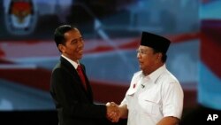 Calon presiden Indonesia Jokowi berjabat tangan dengan Prabowo Subianto sesudah acara debat presiden (15/6). Dalam masa kampanye presiden ini banyak terjadi kampanye hitam seperti misalnya penyebaran tabloid Obor Rakyat yang berisi fitnah terhadap Jokowi. 