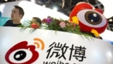 FILE - In this April 27, 2017 file photo, staff members wait for visitors at a booth for Chinese microblogging website Sina Weibo at the Global Mobile Internet Conference (GMIC) in Beijing. Ratcheting up control over Chinese microblogs, regulators…